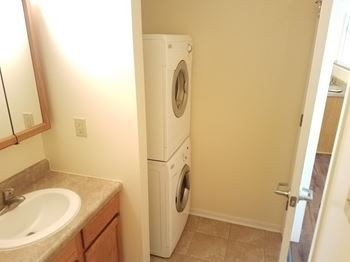 A white washer and dryer in a small laundry room. at Windsor Crest Apartments, Davenport , Iowa